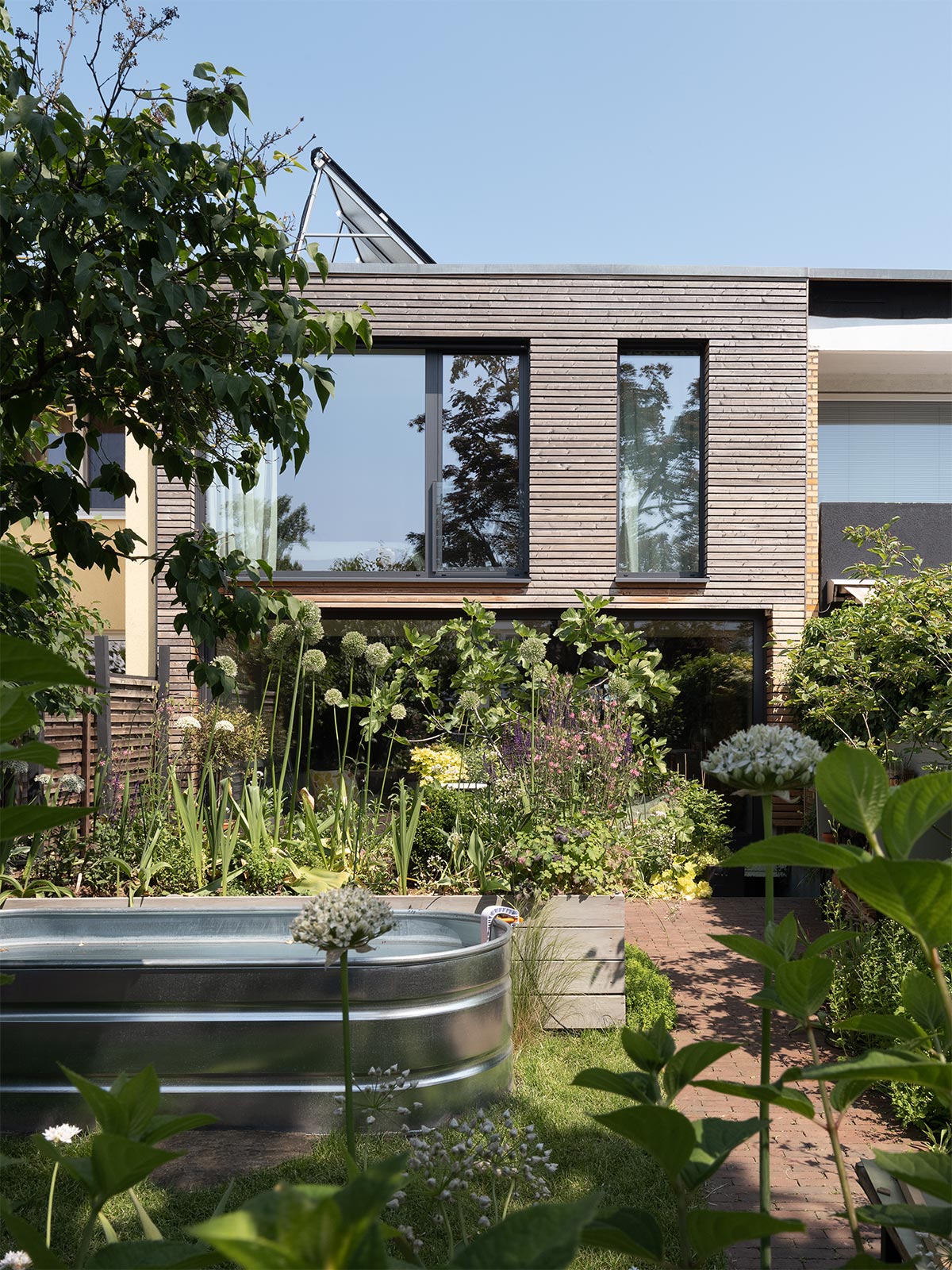 Viel Grün im Garten und reparaturfreundliche Holzfassade ohne Anstrich